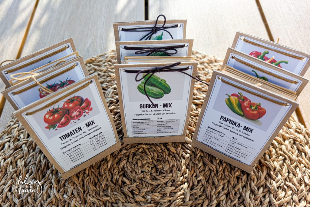 Mehrere DIY Saatgut Geschenkverpackungen aus Kraftpapier mit Tomaten-, Gurken- und Paprika-Mix, mit Kordelverschluss versehen und dekorativ aufgefächert auf einem Tisch arrangiert